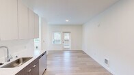 Located at 5823 162nd Ave E in Sumner, Washington, this efficiently designed studio unit offers a thoughtfully arranged single-floor layout that maximizes every square foot. The open-concept kitchen and living area serves as the heart of the space, featuring light hardwood-style flooring, crisp white walls, and recessed lighting that create a clean, modern aesthetic throughout. The kitchen is well-appointed with two-tone cabinetry — dark wood lower cabinets paired with white upper cabinets — complemented by light quartz countertops and stainless steel appliances, including a refrigerator, range, microwave, and dishwasher. The living area benefits from multiple windows and a glass-paneled exterior door that flood the space with natural light and provide access to an outdoor area. The bathroom is outfitted with accessibility-friendly grab bars and a shower, maintaining the same clean, minimalist design found throughout the unit. A dedicated closet offers organized storage space, and a stacked washer and dryer unit adds in-unit laundry convenience. The overall ambiance is bright, fresh, and functional, making this a practical and modern living space in the Sumner area.