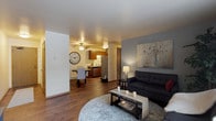 This single-floor residence offers a thoughtfully designed layout that balances comfort and functionality. The spacious living room serves as the heart of the home, featuring rich hardwood-style flooring, a large window with vertical blinds that invites generous natural light, and ample room for multiple seating arrangements. The living area flows seamlessly into the dining space, which is equipped with a ceiling fan and connects directly to the kitchen.

The kitchen is well-appointed with warm wood cabinetry, light stone-finish countertops, a stainless steel range and refrigerator, and a double-basin sink — offering both style and practicality. A dedicated dining area adjacent to the kitchen provides a comfortable setting for everyday meals.

The residence includes two bedrooms, each with hardwood-style flooring. The primary bedroom features a generous walk-in closet outfitted with wire shelving on multiple walls, offering exceptional storage capacity. A second bedroom benefits from a large window with outdoor views.

Two full bathrooms serve the unit, each featuring a tub-shower combination, dark-cabinetry vanity with a white countertop, and hardwood-style flooring, creating a clean and cohesive aesthetic throughout the home.