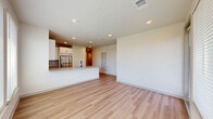 This well-designed two-bedroom, two-bathroom single-story home at 380 Wire Drive in Lakeland, Florida offers a thoughtfully organized layout with modern finishes throughout. The open-concept kitchen and living area serves as the heart of the home, anchored by a large center island with granite countertops, an undermount sink with a matte black faucet, and ample white shaker cabinetry. Stainless steel appliances, including a refrigerator, range, microwave, and dishwasher, complete the kitchen. Light wood-style flooring flows seamlessly across the main living areas, enhancing the bright and airy atmosphere created by recessed lighting and large windows. The living area benefits from natural light and direct outdoor views through a generous window and sliding glass door. Both bedrooms are carpeted and equipped with ceiling fans, offering comfort and practicality. The primary bedroom includes a walk-in closet fitted with wire shelving and an en suite bathroom featuring a walk-in shower with white tile, a frameless glass door, and matte black fixtures. A second closet provides additional storage. The overall ambiance is clean, modern, and move-in ready, reflecting a contemporary aesthetic ideal for comfortable everyday living.