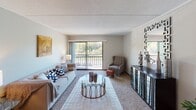 Located at 1513 E Burnsville Pkwy in Burnsville, Minnesota, this single-floor residence offers a well-organized and comfortable layout throughout. The living room serves as the heart of the home, featuring plush carpeting, a textured ceiling, and a large sliding glass door that opens to a private balcony overlooking lush, tree-filled views — filling the space with natural light and a sense of connection to the outdoors. A dedicated dining area adjacent to the living room includes an overhead light fixture, providing an intimate setting for meals. The kitchen is equipped with dark wood cabinetry, a double-basin sink, and light countertops, offering functional workspace and ample storage. The primary bedroom is generously sized with carpeted floors, natural light from a large window, and direct access to an en suite bathroom area featuring a vanity and a full tub-shower combination. A second bedroom provides comfortable proportions, carpeted flooring, and its own window for natural light. A second full bathroom serves the rest of the home, finished with classic white tile and a tub-shower setup. Throughout the residence, neutral tones, consistent carpeting, and a cohesive design palette create a calm and welcoming ambiance.