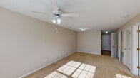Located at 2707 Meridian Dr in Greenville, NC, this single-floor unit offers a practical and well-organized layout with a clean, neutral aesthetic throughout. The living area is generously sized, featuring warm beige carpeting, a ceiling fan with integrated lighting, and abundant natural light streaming through large windows dressed with horizontal blinds. The space carries a bright, open feel with textured ceilings and crisp white trim accenting the walls throughout.

The kitchen is efficiently designed with ample white cabinetry, laminate countertops, and a full suite of black appliances including an electric range, over-the-range microwave, and dishwasher. A window above the sink brings in natural light, and durable tile-style flooring grounds the space.

The bedrooms are well-proportioned, each featuring soft carpeting, ceiling fans, and windows that allow natural light to fill the rooms. The neutral wall tones create a calm and versatile backdrop suitable for a variety of furnishing styles.

The bathroom is thoughtfully appointed with a wide vanity featuring white cabinetry, a large mirror, a combination tub and shower, and tile flooring that coordinates with the kitchen. A hallway connects the bathroom to the main living areas, contributing to a smooth and functional flow throughout the home.