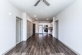 This single-story unit in Douglasville, Georgia offers a well-organized, open-concept layout with modern finishes throughout. The kitchen is a functional centerpiece, featuring white shaker-style cabinetry with brushed metal hardware, granite-look countertops, and a full suite of stainless steel appliances including a refrigerator, range, microwave, and dishwasher. Rich, dark hardwood-style flooring extends through the kitchen and main living areas, creating a cohesive and clean aesthetic.

The living area flows directly from the kitchen, providing an open, airy feel with recessed lighting overhead. Two bedrooms are finished with neutral wall-to-wall carpet, ceiling fans, and windows fitted with blinds that allow natural light while maintaining privacy.

Two bathrooms serve the unit, each with wood-style flooring, white vanity cabinetry, and light stone-toned countertops. One bathroom includes a walk-in closet with wire shelving, while the other features a soaking tub and additional storage. A dedicated laundry area with hookups adds everyday convenience. Overall, the unit presents a clean, contemporary atmosphere suited to comfortable, practical living.