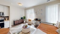 Unit 113 at 610 Park Rd NW in Washington, DC offers a thoughtfully designed single-floor studio layout that maximizes every square foot. The open main living area features warm hardwood-style flooring and large windows dressed with vertical blinds, allowing generous natural light to fill the space and create a bright, welcoming ambiance.

The kitchen runs along one wall in a well-organized galley configuration, equipped with stainless steel appliances including a full-size refrigerator, electric range, built-in microwave, and dishwasher. White shaker-style cabinetry extends to the ceiling, providing ample storage, while a slate-blue subway tile backsplash adds a contemporary accent above the light countertops and undermount sink.

The bathroom features large-format stone-look floor tiles in a neutral gray palette, a vanity with a light countertop and white cabinetry, and a shower with a curtain enclosure. The neutral wall tones and recessed lighting contribute to a clean, functional aesthetic throughout. A dedicated closet provides additional organization near the entryway, which offers tiled flooring for practicality. The overall design balances modern finishes with efficient use of space.