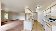 This single-floor residence offers a functional and straightforward layout designed for comfortable everyday living. The kitchen is a standout feature, designed in a galley style with ample white cabinetry trimmed in light wood, generous counter space, a double-basin sink, and white appliances including a refrigerator and electric range. The kitchen opens through a peninsula into the living area, creating a connected, open-concept feel. The living area is finished with warm neutral carpet and features a sliding glass door that leads to a private balcony, allowing natural light to fill the space and providing pleasant outdoor views. The bedrooms are carpeted and finished in neutral tones, with windows that bring in additional natural light. At least one bedroom includes a dedicated closet with a built-in shelf and hanging rod, offering practical storage. The bathroom features tile flooring, a full-size soaking tub with a shower and handheld fixture, a vanity with storage, and clean, light-colored walls throughout. The overall ambiance of the space is clean, neutral, and move-in ready, with consistent light tones and practical finishes that provide a versatile foundation for any interior style.