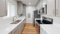 This contemporary apartment offers a well-designed living space of 770 square feet, comprising two bedrooms and two bathrooms. The primary bedroom is generously sized at 130 square feet, providing ample space for comfort and relaxation. Throughout the apartment, warm hardwood flooring adds a touch of elegance and warmth to each room.

The kitchen is a standout feature, boasting a sleek, modern design with light gray cabinetry, white quartz countertops, and stainless steel appliances. The galley-style layout maximizes efficiency while maintaining an open feel. Recessed lighting throughout the apartment, including in the kitchen, ensures bright, even illumination.

Both bathrooms are tastefully appointed with modern fixtures, including vanities with ample storage space and large mirrors. One bathroom features a shower/tub combination, while the other appears to have a stand-alone shower, offering versatility for different preferences.

The living areas are characterized by clean lines and a neutral color palette, creating a bright and airy atmosphere. Large windows in the bedrooms and living spaces allow for plenty of natural light and offer views of the surroundings. Baseboard heating units provide comfortable climate control throughout the seasons.

This well-maintained apartment combines functionality with style, offering a comfortable and contemporary living space in a compact yet efficiently designed floor plan.
