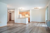 Located at 6735 Pinelake Dr in Madison, Wisconsin, this single-floor, one-bedroom, one-bathroom residence offers a practical and well-appointed layout. The entrance leads into a corridor with warm wood-trimmed doors and light hardwood-style flooring that continues throughout the main living areas. The open-concept living, dining, and kitchen space forms the heart of the home, highlighted by a fireplace and sliding glass door access to a private patio with pleasant views of the tree-lined neighborhood. The kitchen features warm oak cabinetry, white appliances including a range and dishwasher, a double-basin sink, and ample counter space, flowing seamlessly into the dining and living areas. Natural light fills the space through multiple windows. The bedroom is a comfortable, carpeted retreat with a generous closet featuring wood bi-fold doors, contributing to a total of three closets throughout the unit for excellent storage. The bathroom includes an oak vanity with a large mirror and a separate shower area. Additional conveniences include an in-unit laundry area and a dedicated entrance. The overall ambiance is clean, bright, and functional, making this a well-rounded home in a quiet Madison neighborhood.