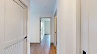 Located in Boston, MA, this thoughtfully designed 2-bedroom, 2-bathroom residence offers a clean, modern aesthetic throughout. Warm hardwood-style flooring flows consistently across the entire single-level layout, complementing the bright white walls and creating a cohesive, contemporary feel.

The open-concept kitchen and living area serves as the heart of the home. The kitchen is well-appointed with two-tone cabinetry — white uppers paired with slate-blue lowers — stainless steel appliances including a full-size refrigerator, range, microwave, and dishwasher, and a white subway tile backsplash. A kitchen island provides additional prep and storage space. Large windows flood the area with natural light and offer city views of the surrounding Boston neighborhood.

Both bedrooms are comfortably sized with clean walls, hardwood-style flooring, and windows that invite natural light. The primary bedroom is a generous size, providing ample space for furnishings. A dedicated closet offers convenient storage.

The two bathrooms are finished with crisp white vertical tile work and matte black hardware accents. One bathroom features a glass-enclosed walk-in shower, while the second includes a soaking tub — both conveying a clean, modern sensibility. The overall ambiance is bright, functional, and move-in ready.