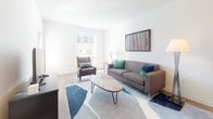 Located at 116 W 9th St in Wilmington, Delaware, this single-floor residence offers a thoughtfully designed layout with contemporary finishes throughout. The open-concept kitchen is a standout feature, outfitted with dark espresso cabinetry, stainless steel appliances including a refrigerator, electric range, and over-the-range microwave, complemented by a textured tile backsplash and a light-toned countertop peninsula with an integrated sink. Warm hardwood-style flooring runs through the kitchen and entry area, creating a cohesive and inviting atmosphere. The living room is bright and airy, benefiting from large windows that allow generous natural light to fill the space. It offers a comfortable, well-proportioned layout suitable for relaxed everyday living. The bedroom features a closet, hardwood-style flooring, and a sizable window with urban views, providing a calm and restful retreat. The full bathroom includes a white subway-tiled tub and shower combination, toilet, and vanity, finished in a clean, minimalist style. Throughout the unit, clean white walls and modern fixtures contribute to a fresh, contemporary aesthetic that is both functional and welcoming.