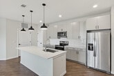 This contemporary 1,150 square foot apartment offers a harmonious blend of style and functionality. The heart of the home is an open-concept living area, seamlessly connecting to a gourmet kitchen. The kitchen boasts white cabinetry, stainless steel appliances, and a large island with pendant lighting, perfect for casual dining or entertaining.

The primary bedroom, measuring 180 square feet, provides a generous retreat. Both bedrooms feature plush carpeting and closet space, with the primary bedroom likely including an en-suite bathroom. The two full bathrooms are modern, with one showcasing a glass-enclosed shower, floating vanity, and wood-style flooring.

Throughout the apartment, wood-style flooring adds warmth and durability. Large windows in the living area flood the space with natural light, while a ceiling fan ensures comfort. The apartment also includes ample storage solutions, with walk-in closets and additional built-in shelving.

The neutral color palette and clean lines create a fresh, inviting atmosphere, allowing residents to easily personalize the space. This thoughtfully designed apartment combines comfort and contemporary living, making it an ideal home for those seeking a modern urban lifestyle.