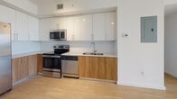 This single-floor residence showcases a contemporary design highlighted by light wood-look tile flooring that flows consistently throughout the living areas, bedrooms, and common spaces, creating a cohesive and airy aesthetic. The open-concept living and dining area connects seamlessly to the kitchen, which is outfitted with high-gloss white upper cabinetry, warm wood-tone lower cabinets, white quartz countertops, and a subway tile backsplash. Stainless steel appliances include a side-by-side refrigerator with an ice and water dispenser, a range, microwave, and dishwasher.

The living area benefits from abundant natural light through floor-to-ceiling sliding glass doors that open to a private balcony, offering elevated outdoor views. Ceiling fans are present in the main living area and bedrooms, enhancing comfort and air circulation. The bedrooms feature roll-down shades, closets with built-in shelving, and access to outdoor views via large windows or balcony doors.

Both bathrooms are finished with warm wood-tone tile surrounds encasing full soaking tubs with overhead rain showerheads, complemented by wood-tone vanity cabinetry and light tile flooring. The overall ambiance is clean, bright, and modern.