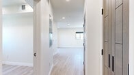 This thoughtfully designed one-bedroom, one-bathroom unit on the fifth floor of 1047 Fedora Street offers a clean, contemporary living experience in Los Angeles. Light-toned hardwood-style flooring runs throughout the space, complementing the crisp white walls and recessed lighting that create a bright, airy atmosphere.

The open living area is a standout feature, anchored by large black-framed sliding glass doors that lead to a private balcony, inviting abundant natural light and views of the surrounding cityscape. The kitchen is well-appointed with floor-to-ceiling wood-toned cabinetry, light countertops, stainless steel appliances including a refrigerator, over-the-range microwave, and electric range, all set against a clean white backsplash.

The bedroom is a calm retreat with light wood flooring, a window fitted with a roller shade, and dual wood-paneled doors — one leading to a closet and one to the hallway — outfitted with sleek matte black hardware. The bathroom features a modern aesthetic with herringbone-tiled walk-in shower enclosed by black-framed glass doors, mosaic tile flooring, a wall-mounted mirror with black detailing, and a wood-accented vanity. The entrance provides a welcoming transition into the rest of the unit, tying together the cohesive, modern design throughout.