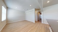 Located at 5811 102nd Street in Lubbock, Texas, this single-story home offers a clean, modern interior designed for comfortable living. The open layout is highlighted by light hardwood-style flooring that runs throughout, contributing to a bright and cohesive aesthetic. Neutral wall tones and crisp white trim create a fresh, move-in-ready atmosphere that complements a variety of décor styles.

The main living area is generously proportioned, featuring recessed lighting that provides even, ambient illumination across the space. A distinctive arched entryway adds an elegant architectural detail, lending character and visual interest as it connects the living area to the hallway beyond. The hallway leads further into the home, offering a glimpse of additional rooms bathed in natural light.

Ceiling-mounted HVAC vents are thoughtfully integrated throughout, ensuring year-round comfort. The consistent use of quality finishes — from the smooth walls to the well-maintained flooring — reflects careful attention to detail. The overall ambiance of the home is calm, airy, and welcoming, making it an ideal setting for both everyday living and entertaining. This Lubbock property combines functional design with understated style in a well-organized single-floor plan.