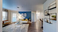 Located at 6225 Castlegate Dr W in Castle Rock, Colorado, this well-appointed 2-bedroom, 2-bathroom single-floor residence offers a thoughtfully designed layout across a comfortable footprint. The open-concept living and dining area serves as the heart of the home, highlighted by a striking bold blue geometric accent wall, rich wood-style flooring, crown molding, and a sliding glass door that invites natural light and provides access to an outdoor patio. Built-in shelving adds functional character alongside the main living area. The kitchen features white cabinetry, light stone countertops, stainless steel appliances, and a convenient pass-through to a dedicated in-unit laundry room with overhead shelving. The primary bedroom continues the bold blue accent wall theme, complemented by plush carpeting, generous natural light from large windows, and ample closet space. The second bedroom is equally comfortable, with soft carpet, neutral tones, and direct access to a closet. Two full bathrooms serve the residence, each with clean, neutral finishes. A connecting hallway ties all spaces together efficiently. This residence combines contemporary design details with practical functionality in a well-organized single-level floor plan.