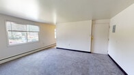 Located at 1072 Eastway Dr in Youngstown, Ohio, this single-floor unit offers a straightforward and functional layout spread across several well-defined spaces. The living area is generously proportioned, featuring grey wall-to-wall carpeting, neutral white walls, and baseboard heating. Natural light filters in through windows that offer views of the surrounding neighborhood, creating a bright and open feel. A dedicated entry door with a secured lock provides direct access to the living space.

The kitchen is efficiently designed with white cabinetry, butcher block-style countertops, vinyl tile flooring, and white appliances including a gas range and a full-sized refrigerator, providing all the essentials for daily meal preparation. Upper cabinets offer ample storage space.

The bedrooms are carpeted and finished with neutral tones, each offering closet access and adequate space for furnishings. The rooms connect logically through interior doorways, supporting a practical flow throughout the unit.

The bathroom is outfitted with a full soaking tub and shower combination, a wall-mounted sink, and a privacy window that allows natural light while maintaining seclusion. The clean, white finishes give the bathroom a simple and functional character.

Overall, this unit presents a clean, no-frills living environment with practical amenities suited for comfortable everyday living.