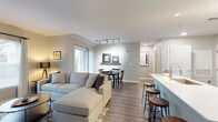 This well-appointed 2-bedroom, 2-bathroom single-floor residence offers a thoughtfully designed open-concept layout with modern finishes throughout. The living and dining area forms the heart of the home, featuring wood-style flooring, large windows that flood the space with natural light, and a seamless flow into the kitchen. Track lighting above the dining area adds a contemporary touch, while a decorative floating shelf serves as a subtle design accent.

The kitchen is equipped with stainless steel appliances, including a gas range, microwave, and refrigerator, complemented by white upper cabinetry, dark lower cabinetry, and clean white countertops. A breakfast bar with seating provides additional dining and social space.

Both bedrooms are carpeted and serene, with ample closet space — one bedroom features a walk-in closet and direct access to a full bathroom. Each bathroom is finished with dark vanity cabinetry, white countertops, stylish lighting fixtures, and tub-shower combinations.

A dedicated in-unit laundry room houses a full-sized washer and dryer, adding everyday convenience. Neutral wall tones and consistent wood-style flooring in the main living areas create a cohesive, modern aesthetic throughout the residence.