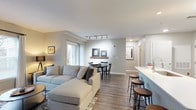This well-appointed 2-bedroom, 2-bathroom single-floor residence offers a thoughtfully designed open-concept layout with modern finishes throughout. The living and dining area forms the heart of the home, featuring wood-style flooring, large windows that flood the space with natural light, and a seamless flow into the kitchen. Track lighting above the dining area adds a contemporary touch, while a decorative floating shelf serves as a subtle design accent.

The kitchen is equipped with stainless steel appliances, including a gas range, microwave, and refrigerator, complemented by white upper cabinetry, dark lower cabinetry, and clean white countertops. A breakfast bar with seating provides additional dining and social space.

Both bedrooms are carpeted and serene, with ample closet space — one bedroom features a walk-in closet and direct access to a full bathroom. Each bathroom is finished with dark vanity cabinetry, white countertops, stylish lighting fixtures, and tub-shower combinations.

A dedicated in-unit laundry room houses a full-sized washer and dryer, adding everyday convenience. Neutral wall tones and consistent wood-style flooring in the main living areas create a cohesive, modern aesthetic throughout the residence.