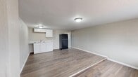 Located at 3304 W Hwy 80 in Big Spring, Texas, this single-floor, one-bedroom, one-bathroom unit offers a practical and functional layout. The open-concept kitchen and living area forms the heart of the space, featuring durable wood-look flooring that extends throughout the unit, neutral gray walls, and a textured ceiling. The kitchen is equipped with white cabinetry, a countertop with sink, and a black refrigerator, keeping everything within easy reach. Flush-mount ceiling lighting provides consistent illumination across the combined living and kitchen space.

The bedroom is a comfortable, well-proportioned room outfitted with a ceiling fan with light fixture, continued wood-look flooring, and two windows that invite natural light. A dedicated closet offers convenient storage. An additional area with multiple doorways provides access to the closet and connects the various rooms of the unit.

The bathroom is a standout feature, showcasing a full soaking tub and shower combination accented by a striking marble-patterned surround in white and gray tones with brushed nickel fixtures, lending a clean, updated aesthetic to the space. Wood-look flooring carries through here as well, tying the unit together with a cohesive design. Overall, this unit presents a straightforward, move-in-ready living space suited for efficient, comfortable everyday living.