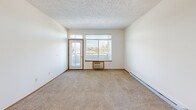 Located at 5317 Palouse Hwy in Spokane, WA, this 2-bedroom, 2-bathroom unit offers a well-organized single-floor layout designed for comfortable everyday living. The open-concept living room features plush carpeting, a textured ceiling, and large windows with a sliding door that invite natural light and provide pleasant views of surrounding greenery. Baseboard heating is present throughout the unit. The kitchen is efficiently laid out with warm wood-toned cabinetry, a white appliance package including a refrigerator, range, and microwave, and a raised breakfast bar that connects seamlessly to the living area. Hardwood-style flooring runs through the kitchen and entryway, creating a clean contrast to the carpeted living spaces. Both bedrooms are carpeted and well-lit by windows overlooking mature trees. The primary bedroom features a spacious walk-in closet outfitted with wire shelving, while the second bedroom includes a sliding double-door closet. Each bathroom is equipped with a full tub-shower combination, wood-toned cabinetry, and hardwood-style flooring. The unit's clean, neutral palette and functional design make it a practical and inviting home in a convenient Spokane location.