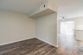 This two-floor residence offers a well-designed layout with modern updates throughout. The living room serves as a central gathering space, finished with durable wood-look plank flooring, neutral gray walls, and a fireplace framed by a granite surround. Two windows allow natural light to fill the room, creating a bright and welcoming atmosphere.

The kitchen is thoughtfully equipped with white shaker-style cabinetry, granite countertops, a classic subway tile backsplash, and a full suite of stainless steel appliances including a range, microwave, and refrigerator. A peninsula countertop provides additional prep space, and a sliding glass door connects the kitchen to an outdoor area.

The bathrooms feature granite-topped vanities with white cabinetry, framed mirrors, and wood-look or tile flooring. One bathroom includes a separate water closet for added privacy.

Bedrooms are carpeted and receive natural light through windows with blinds. At least one bedroom includes a mirrored sliding closet. A dedicated laundry room houses a full-size washer and dryer alongside upper cabinetry for storage. Throughout, the space maintains a clean, neutral palette with consistent finishes that contribute to a cohesive and functional interior.