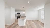 This single-story unit in Biloxi, Mississippi offers a clean, modern layout designed for comfortable everyday living. A welcoming entryway with recessed lighting and wood-look luxury vinyl plank flooring leads into the open-concept kitchen and living area. The kitchen is a standout feature, showcasing granite countertops, white shaker cabinetry, stainless steel appliances, and a peninsula island with a double undermount sink and pendant lighting overhead — ideal for both meal preparation and casual dining. The adjoining living area provides an open, airy feel with crisp white walls and continuity of flooring throughout.

The spacious primary bedroom features plush wall-to-wall carpeting, a ceiling fan with light fixture, and a window with blinds that allows for natural light. A second room with vinyl plank flooring and a window offers additional flexibility as a den or office space. The full bathroom is finished with wood-look flooring, a tub/shower combo, white vanity cabinetry, and granite countertops consistent with the rest of the unit's finishes.

Throughout the space, a neutral color palette, recessed lighting, and consistent materials create a cohesive and move-in ready environment suited for modern living.