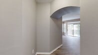 Located at 8636 Villa Point in Orlando, FL 32810, this single-floor unit offers 880 square feet of well-designed living space across 2 bedrooms and 2 bathrooms. Light wood-look flooring runs throughout, complemented by neutral gray walls and white trim, creating a clean, cohesive aesthetic. The combined kitchen and living room area serves as the heart of the home. The galley-style kitchen is equipped with stainless steel appliances including a full-size refrigerator and electric range, white shaker cabinets with brushed nickel hardware, dark granite-style countertops, and a double sink. The living area is bright and open, featuring a ceiling fan and a sliding glass door that opens to a private balcony with outdoor views. Both bedrooms include ceiling fans, wood-look flooring, and closet access. The primary bedroom measures 160 square feet and benefits from natural light through arched windows. Each bathroom features white vanity cabinets and dark granite-style countertops with round undermount sinks and large mirrors. The bathrooms are finished with wood-look flooring and ample lighting. Two closets provide generous storage, including a walk-in closet with wire shelving systems. A hallway connects the private areas of the unit efficiently.