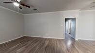 This well-appointed single-story home offers three bedrooms, two bathrooms, and a practical layout designed for comfortable everyday living. Throughout the home, durable wood-look flooring provides a cohesive and modern aesthetic, complemented by neutral gray walls and crisp white trim.

The combined kitchen and living area serves as the heart of the home. The kitchen is outfitted with gray shaker-style cabinetry, granite countertops, a subway tile backsplash, a stainless steel dishwasher, and ample storage. Crown molding and a ceiling fan add a refined touch to the adjoining living area, which benefits from a large window that brings in natural light.

Each of the three bedrooms features wood-look flooring and a ceiling fan. The primary bedroom is generously sized and includes dedicated closet space with built-in shelving and hanging rods. The additional bedrooms are well-proportioned and similarly finished.

Both bathrooms are finished with granite-topped vanities, undermount sinks, brushed nickel fixtures, and large mirrors. The flooring continues the wood-look theme found throughout the home. A hallway connects the bedrooms and bathrooms, providing a well-organized flow. Three closets offer ample storage throughout the residence.