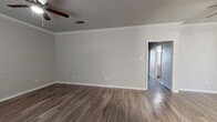 This well-appointed single-story home offers three bedrooms, two bathrooms, and a practical layout designed for comfortable everyday living. Throughout the home, durable wood-look flooring provides a cohesive and modern aesthetic, complemented by neutral gray walls and crisp white trim.

The combined kitchen and living area serves as the heart of the home. The kitchen is outfitted with gray shaker-style cabinetry, granite countertops, a subway tile backsplash, a stainless steel dishwasher, and ample storage. Crown molding and a ceiling fan add a refined touch to the adjoining living area, which benefits from a large window that brings in natural light.

Each of the three bedrooms features wood-look flooring and a ceiling fan. The primary bedroom is generously sized and includes dedicated closet space with built-in shelving and hanging rods. The additional bedrooms are well-proportioned and similarly finished.

Both bathrooms are finished with granite-topped vanities, undermount sinks, brushed nickel fixtures, and large mirrors. The flooring continues the wood-look theme found throughout the home. A hallway connects the bedrooms and bathrooms, providing a well-organized flow. Three closets offer ample storage throughout the residence.