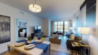 This single-floor residence at 2100 Progress Pkwy in Schaumburg, Illinois, showcases a thoughtfully designed open-concept layout that seamlessly connects the living, dining, and kitchen areas. The living room is a standout space, highlighted by large sliding glass doors that flood the interior with natural light and provide direct access to a private balcony with outdoor views. A bold, large-scale abstract wall mural serves as a striking focal point, complementing the hardwood-style flooring and contemporary furnishings.

The kitchen is well-appointed with dark espresso cabinetry reaching toward the ceiling, stainless steel appliances, and a bright white countertop island with bar seating. Pendant lighting above the island adds a refined touch, while the wood-look flooring ties the space cohesively to the main living area.

The bedrooms offer a calm, restful atmosphere, each featuring plush carpeting, generous windows that invite natural light, and ample room for furnishings. The bathroom is finished with a dark-toned vanity, white countertops, wood-look tile flooring, and a glass-enclosed walk-in shower, creating a clean and modern aesthetic throughout.