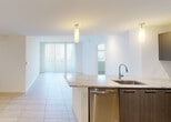 Located in Doral, FL, this single-floor residence offers a clean, modern aesthetic throughout its well-designed layout. The open-concept living and dining area is bathed in natural light, thanks to large sliding glass doors fitted with vertical blinds that provide views of the outdoors. Light-toned porcelain tile flooring runs through the main living spaces, lending a bright and cohesive feel.

The kitchen is a standout feature, showcasing sleek dark cabinetry with a high-gloss finish, granite countertops, a deep stainless steel sink, and a full suite of stainless steel appliances including a refrigerator, range, microwave, and dishwasher. Track lighting and pendant fixtures complete the polished look.

The bedrooms are carpeted for comfort and receive ample natural light through large windows with outdoor views. One bedroom includes a ceiling fan, adding to the functional design.

Two bathrooms serve the residence. One features a combined tub and shower with white tile surround, a granite-topped vanity, and tile flooring. The second, more spacious bathroom offers a glass-enclosed walk-in shower, an extended granite vanity with an undermount sink, and matching tile floors—ideal as a primary bath.

Overall, the space presents a bright, contemporary atmosphere well-suited to modern living.