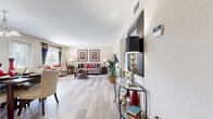 Located at 541 Oak Reserve Ln in Winter Park, Florida, this well-designed single-floor residence offers a thoughtful layout across one bedroom, one bathroom, and multiple functional living spaces. The welcoming entrance opens into a spacious combined living and dining area bathed in natural light from large windows dressed with decorative curtains. The living room features light wood-style flooring, a textured ceiling, and generous room for comfortable seating arrangements. Adjacent, the dining area is anchored by a chandelier overhead and provides direct access to the outdoors through a glass door. The kitchen is efficiently designed with warm maple cabinetry, dark granite-style countertops, a mosaic tile backsplash, tile flooring, and black appliances, offering ample storage and workspace. The bedroom is a comfortable retreat with plush carpeting, a large window with natural views, and a closet. A dedicated office provides carpeted, quiet space with abundant natural light — ideal for remote work or reading. The full bathroom includes a tub-shower combination with clean white tile surround. A hallway connects all areas of the home seamlessly, contributing to the efficient, functional flow of this well-maintained Winter Park residence.