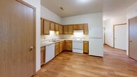 Located at 169 Marshs Ln in Elyria, Ohio, this single-story, 3-bedroom, 2-bathroom home offers a well-organized layout with a practical mix of living spaces. Warm hardwood-style flooring runs throughout the main living areas, complemented by wood trim detailing on doors and baseboards that adds a consistent, cohesive finish.

The living room is a bright, open space anchored by a ceiling fan and a large sliding glass door that fills the room with natural light and provides views of the outdoor greenery. The kitchen features oak cabinetry, ample counter space in an L-shaped configuration, and includes a dishwasher, range, and refrigerator. An adjacent pantry adds convenient storage.

The three bedrooms are carpeted and well-lit, with the primary bedroom offering a generously sized walk-in closet equipped with wire shelving systems. The secondary bedrooms are comfortable in scale, each with windows that bring in natural light. The two bathrooms are cleanly appointed with oak vanities and tub-shower combinations.

Additional highlights include a dedicated laundry room with hardwood-style flooring and utility hookups, a utility room, and an attached garage with interior access. Four closets throughout the home provide ample storage. The overall layout is efficient and accessible, making this a well-rounded single-story home.