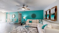 Located in Orlando, FL, this well-appointed 2-bedroom, 2-bathroom single-floor home offers a thoughtfully designed layout with a cohesive coastal-inspired aesthetic. The living room makes a striking first impression with a bold teal accent wall, wood-look flooring, and a ceiling fan overhead, creating a bright and energetic atmosphere. A welcoming entryway with natural light from sidelight windows leads seamlessly into the main living area.

The kitchen is efficiently designed with white shaker cabinetry, light countertops, a subway tile backsplash, and a full suite of stainless steel appliances including a refrigerator, range, and dishwasher. Wood-look flooring carries through this space for a clean, modern look.

The primary bedroom offers a comfortable, carpeted retreat with a teal accent wall, ceiling fan, and a natural light window. A second bedroom mirrors this coastal style with matching accent colors and soft carpeting. Both bathrooms feature white vanity cabinetry, broad countertops, and wood-look flooring. The primary bath includes a dual-sink vanity, while the second bath offers a generous single-sink setup with ample storage.

A dedicated laundry room with full-size washer and dryer adds everyday convenience, completing this well-rounded and move-in-ready Orlando home.