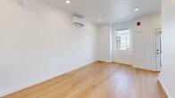 Located at 566 S Redwood Rd in Salt Lake City, UT, this modern 1-bedroom, 1-bathroom unit is thoughtfully designed across three floors. The ground level features an attached garage with a full-size door, offering secure parking and additional storage. The main living floor showcases an open-concept layout that combines the dining room, kitchen, and living room into a bright, cohesive space. Light hardwood flooring flows throughout, complementing crisp white walls and recessed lighting. The kitchen is a standout feature, equipped with dark navy cabinetry, white quartz countertops, stainless steel appliances including a French door refrigerator, electric range, microwave, and dishwasher, along with a peninsula that adds extra prep and seating space. Natural light enters through multiple windows, and a wall-mounted mini-split system provides efficient climate control. The upper floor houses the spacious primary bedroom with hardwood flooring, a wall-mounted mini-split unit, and a bright window. The full bathroom includes a dark-toned vanity with white countertop, a soaking tub with shower, and hardwood flooring. Additional highlights include multiple closets, a dedicated laundry area, a balcony, and a utility room, making this a well-appointed and functional multi-level home.