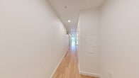 Located on the seventh floor at 1100 Boylston Ave in Seattle's Capitol Hill neighborhood, this modern two-bedroom residence offers a thoughtfully designed single-floor layout with a clean, contemporary aesthetic throughout. Light wood flooring runs seamlessly across every room, complementing the crisp white walls and creating a bright, cohesive atmosphere.

The spacious living area is a standout feature, bathed in natural light through large floor-to-ceiling windows that frame views of the surrounding Seattle cityscape. A tray ceiling adds architectural dimension to the room, while a wall-mounted mini-split unit ensures year-round comfort. The kitchen is equipped with stainless steel appliances, including a range and refrigerator, and features warm wood cabinetry that adds a touch of texture to the otherwise minimalist palette.

The generously sized primary bedroom offers ample space, enhanced by a high clerestory window that draws in additional natural light. The second bedroom is equally well-appointed and versatile. A dedicated closet provides practical storage, and a long, well-lit hallway with recessed lighting connects the rooms with a sense of flow and purpose. The bathroom is neatly integrated into the layout, completing this efficient and stylish urban residence.