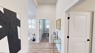 Located on Old Monrovia Rd NW in Huntsville, Alabama, this single-floor home showcases a clean, modern aesthetic defined by bright white walls, durable wood-look flooring, and an open, airy layout. The welcoming entryway sets the tone with tall ceilings, a decorative console, and crisp white trim accented by matte black hardware — a design detail carried consistently throughout the home.

The living room offers a comfortable, light-filled retreat with large windows dressed in sheer curtains that invite natural light. The kitchen is well-appointed with white shaker cabinets, stainless steel appliances, subway tile backsplash, and a central island with pendant lighting overhead — ideal for both everyday cooking and casual dining.

The bedrooms are carpeted and tranquil, each featuring windows with outdoor views and ample natural light. The primary bedroom is accompanied by a spacious en-suite bathroom boasting a dual-sink vanity with white cabinetry and matte black fixtures, plus a generously sized walk-in closet with wire shelving throughout. A secondary bathroom includes a tub-shower combination with white tile surround and matching black hardware accents.

Every detail of this home reflects a cohesive, contemporary design that balances functionality with refined style.