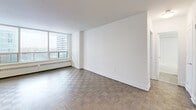 Located on the 9th floor at 65 Forest Manor Rd in Toronto's north end, this well-appointed one-bedroom, one-bathroom unit offers a thoughtfully designed layout across a comfortable single floor. Parquet hardwood flooring flows throughout the living, dining, and bedroom areas, adding warmth and character to the space.

The open-concept living and dining area is generously sized and bathed in natural light, courtesy of large floor-to-ceiling windows that frame sweeping city and skyline views. A private balcony extends the living space outdoors, accessible directly from the main living area.

The modern kitchen is equipped with stainless steel appliances — including a range, dishwasher, and built-in microwave — complemented by white shaker cabinetry, a subway tile backsplash, dark countertops, and a breakfast bar peninsula. Tile flooring completes the clean, functional kitchen aesthetic.

The bedroom is a comfortable, well-proportioned retreat featuring parquet flooring, a large window with city views, and mirrored sliding closet doors that enhance the sense of space. Additional storage is provided by three closets throughout the unit.

The bathroom features a full soaking tub with a handheld shower, framed by classic white subway tile surround and chrome fixtures. The unit also includes an entrance, hallway, and ample overall storage, making it a practical and polished urban residence.