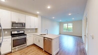 Located at 41 W Prospect St in Waldwick, NJ, this well-appointed one-bedroom, one-bathroom residence offers a thoughtfully designed single-floor layout with modern finishes throughout. The open-plan kitchen and living area serves as the heart of the home, featuring crisp white shaker cabinetry, quartz countertops, a subway tile backsplash, and a full suite of stainless steel appliances including a gas range, microwave, and refrigerator. Light wood-tone flooring flows seamlessly through the living and bedroom spaces, lending warmth and cohesion to the interior. The bedroom is a comfortable, well-proportioned retreat filled with natural light from large windows that frame lush, green outdoor views. Recessed lighting adds a clean, modern touch to the ceiling. A dedicated walk-in closet off the bedroom provides generous storage with multi-level wire shelving. The bathroom is finished with a white vanity with quartz countertop, an oversized mirror, contemporary chrome-accented light fixtures, and elegant dark tile flooring. Neutral warm-white walls and recessed lighting throughout create a bright, welcoming ambiance, making this Waldwick residence a polished and functional place to call home.