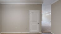 Located at 2000 Teaching Dr in Cary, NC, this single-floor residence offers a well-designed layout with comfortable living spaces throughout. The open-concept living area is highlighted by plush carpeting, crown molding, and a ceiling fan, creating a welcoming atmosphere. Large windows and a glass-paneled exterior door allow natural light to fill the space while providing views of the outdoors.

The kitchen is positioned adjacent to the living area and features rich, dark-stained cabinetry, dark granite-style countertops, and black appliances including a range, over-the-range microwave, and refrigerator. A breakfast bar with decorative columns connects the kitchen to the main living space.

The bedrooms are carpeted and finished with neutral-toned walls, ceiling fans, and window blinds that allow for adjustable natural light. Each room offers a comfortable sense of space and easy access to closet storage.

The bathrooms include a full tub-shower combination with built-in shelving in one, and a soaking tub with an overhead shower and additional shelving in another. Both are finished in clean white tones. Throughout the home, arched interior doors, crown molding, and consistent neutral finishes contribute to a cohesive and polished aesthetic.