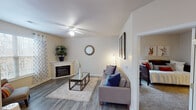 This single-floor residence offers a thoughtfully designed layout with a warm and inviting atmosphere throughout. The living room serves as the heart of the home, featuring wood-style flooring, a ceiling fan, and a corner fireplace that anchors the space with a cozy focal point. A glass-top coffee table and comfortable sofa make it an ideal area for relaxing or entertaining. Adjacent to the living room, the dining area benefits from abundant natural light streaming through large windows and a glass-panel door, creating an airy, open feel. Sheer curtains add a soft, elegant touch to the space.

The kitchen is well-equipped with white shaker-style cabinetry, dark countertops, and black appliances, including a range, dishwasher, and refrigerator, all set over wood-style flooring for a clean, modern look. The bedroom offers plush carpeting, generous natural light from large windows, and ample space for furnishings. The full bathroom features a tub-shower combination, a white vanity with a single sink, and wood-style flooring. Completing the unit is a dedicated in-unit laundry area with a full-size washer and dryer, adding everyday convenience to this comfortable and functional home.