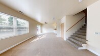 Located at 1135 High Ave in Oshkosh, Wisconsin, this two-story home offers four bedrooms and four bathrooms across a well-distributed layout. The main floor hosts the larger portion of the living space, including a combined kitchen and living room area, while the upper floor accommodates additional bedrooms and bathrooms.

The living room is bright and open, featuring neutral beige walls, soft carpeting, and multiple windows that invite generous natural light. A sliding glass door provides direct outdoor access and views of the surrounding greenery, enhancing the airy feel of the space.

The kitchen is efficiently designed with white cabinetry, a peninsula countertop with warm-toned surfaces, and white appliances including a range, dishwasher, and refrigerator. Stone-look tile flooring grounds the space and contrasts with the carpeted living areas.

The bedrooms are finished with the same warm neutral palette and plush carpeting, each benefiting from natural light through well-placed windows. The primary bedroom includes closet access and comfortable proportions. Additional bedrooms offer clean, versatile spaces suitable for various uses.

Each of the four bathrooms features a full tub-shower combination with chrome fixtures, wood-look vinyl flooring, and a pedestal or wall-mounted sink, maintaining a consistent and functional aesthetic throughout the home.