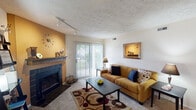 Located at 329 Runaway Bay Cir in Mishawaka, Indiana, this single-floor residence offers a well-organized and comfortable layout across several distinct living areas. The living room serves as a central gathering space, highlighted by a tile-surround fireplace set against a warm accent wall, track lighting, textured ceilings, and a sliding glass door that fills the room with natural light and provides outdoor access. The dining area adjacent to the kitchen features a bold red accent wall, adding a vibrant focal point to the space. The galley-style kitchen is efficiently designed with ample warm-toned wood cabinetry, white appliances including a range and dishwasher, and generous counter space. A dedicated laundry area is accessible directly from the kitchen. The primary bedroom showcases a distinctive yellow accent wall with a personalized touch, complemented by hard surface flooring. A secondary bedroom offers carpeted flooring and a bright window, comfortably accommodating multiple beds. Two bathrooms serve the home — one featuring a vanity with wood cabinetry and elegant wall sconces, and the other offering a full tub-shower combination with tiled surround. Throughout the home, textured ceilings and neutral tones create a cohesive, inviting ambiance.