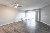 Located at 601 Pembroke Ave in Norfolk, Virginia's 23507 zip code, this single-floor residence offers a well-designed layout with a clean, modern aesthetic throughout. The open living area is finished with durable hardwood-style flooring in a warm gray tone, complemented by neutral wall colors that create a bright and airy atmosphere. A ceiling fan provides overhead comfort, while a large sliding glass door floods the space with natural light and offers access to an outdoor area. The kitchen is thoughtfully appointed with crisp white cabinetry, granite-style countertops, a classic subway tile backsplash, and a full suite of stainless steel appliances including a gas range, over-the-range microwave, and dishwasher. The bathroom continues the home's modern finishes, featuring white shaker-style cabinetry, granite-style countertops with brushed nickel hardware, and hardwood-style flooring that ties cohesively to the rest of the unit. A closet with double doors provides convenient storage. The overall design balances functionality with contemporary style, making this a practical and attractive space in the heart of Norfolk.