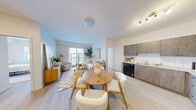 Located at 7 Belvedere Avenue SE in Calgary, this 2-bedroom, 2-bathroom unit is designed with a clean, modern aesthetic and a neutral colour palette that creates a bright and welcoming atmosphere throughout. The open-concept living, dining, and kitchen area forms the heart of the home, featuring light-toned laminate flooring, white tile backsplash, and textured wood-grain cabinetry paired with black and stainless steel appliances, including a full-size refrigerator and dishwasher. A sliding glass door in the living room fills the space with natural light and provides outdoor views. The primary bedroom is a comfortable retreat with a window, light flooring, and ample wall space. The second bedroom mirrors the same bright, airy feel. Both bathrooms are well-appointed; one features a glass-enclosed stand-up shower with white tile surround and a vanity with stone-finish countertop. A dedicated laundry room houses a stacked washer and dryer unit alongside built-in wire shelving for added storage. A separate closet and entrance hallway round out the practical layout, making this unit a functional and well-organized home in a growing Calgary community.