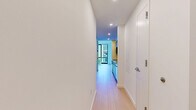 This contemporary 590 square foot apartment in Jersey City offers a well-designed living space with two bedrooms and one bathroom. The primary bedroom, measuring 140 square feet, provides ample space for comfort. The apartment showcases a modern aesthetic with clean lines and a minimalist approach.

The living areas feature light-toned hardwood flooring that extends throughout, creating a seamless and spacious feel. Large windows in the bedrooms and living space flood the interior with natural light and offer impressive city views, enhancing the urban living experience.

The kitchen boasts a sleek design with modern cabinetry, stainless steel appliances, and a linear layout that maximizes efficiency. A contrasting yellow floor in the kitchen area adds a vibrant touch to the otherwise neutral color palette.

The bathroom is equipped with a glass-enclosed shower, a floating vanity, and a large illuminated mirror, embodying contemporary style and functionality. Sliding doors in the bedrooms help to maximize space utilization.

The apartment's layout includes two hallways, facilitating easy movement between rooms. Overall, this property presents a perfect blend of modern design and practical urban living, ideal for those seeking a stylish and efficient living space in the heart of Jersey City.