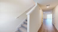 Located at 9281 Cape Verde Dr in Thonotosassa, FL, this two-story home offers a well-designed layout across two floors. The main level houses the kitchen and living area, a garage, a laundry room, and a bathroom, while the upper floor is dedicated to the three bedrooms, including a spacious primary suite, along with additional bathrooms and closets.

The kitchen is a standout feature, showcasing granite countertops, a peninsula with an undermount sink, white shaker cabinetry, a subway tile backsplash, and a full suite of stainless steel appliances. It flows naturally into the open living area, creating a cohesive and functional shared space. Light wood-tone luxury vinyl plank flooring runs throughout both levels, lending a clean, modern aesthetic.

The bedrooms are bright and airy with neutral walls and generous proportions. The bathrooms are well-appointed — one features a pedestal sink with brushed nickel fixtures, while another includes a tiled tub-shower surround, white vanity with granite countertop, and wood-look flooring. A carpeted staircase with a white railing connects the two floors, complemented by clean hallways. The home's consistent use of white trim, neutral tones, and modern finishes creates a cohesive and move-in-ready feel throughout.
