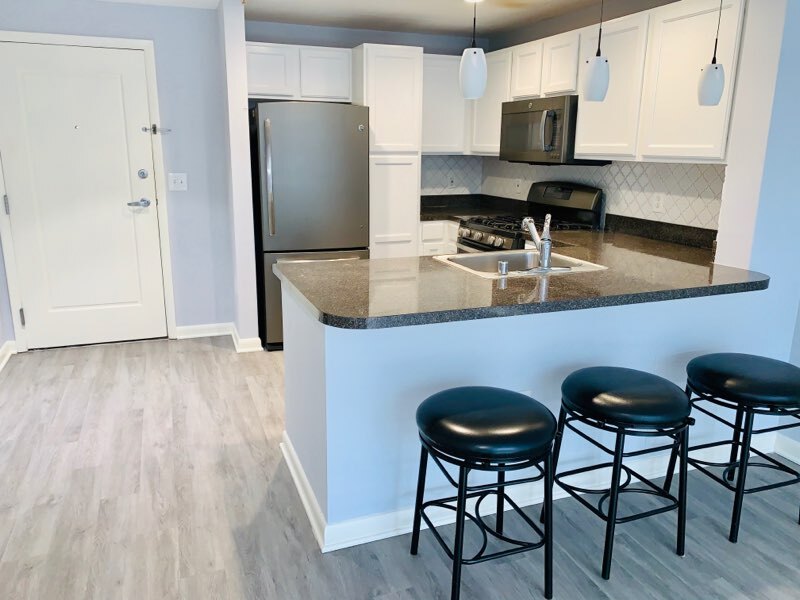 Bright & modern kitchen with white cabinetry & backsplash - 350 G St SW