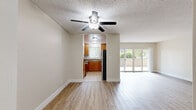 Located at 4851 Hazeltine Ave in the Sherman Oaks neighborhood of Los Angeles, this well-appointed 1-bedroom, 1-bathroom unit offers a comfortable and functional layout across a single floor. The living room is an open, light-filled space featuring warm luxury vinyl plank flooring, neutral beige walls, a textured ceiling, and a ceiling fan. Large sliding glass doors lead to a private balcony, framing lush greenery and allowing abundant natural light to pour in. A glimpse into the living area also reveals a stacked in-unit washer and dryer, adding everyday convenience. The kitchen is efficiently designed with rich honey-toned wood cabinetry, granite countertops, stainless steel appliances including a refrigerator, range, microwave, and dishwasher, and light tile flooring. A window above the sink provides natural ventilation and light. The spacious bedroom features the same wood-look flooring, a textured ceiling, a window with palm tree views, and a sliding double-door closet offering generous storage. The bathroom is clean and classic, with white subway tile surrounding a soaking tub, a wood vanity with granite countertop, and a mirrored cabinet above.
