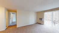 Located at 4 Derry Park Dr in Middleboro, Massachusetts, this two-floor residence offers a clean, functional layout across multiple rooms finished in neutral tones throughout. The living areas are finished with wall-to-wall carpet in a warm beige palette, complemented by cream-colored walls and textured ceilings that lend a consistent, understated aesthetic. Baseboard heating runs along the perimeter of most rooms, and wall-unit air conditioners provide climate control where needed. Natural light filters in through double-pane windows fitted with blinds, brightening the generously sized main living spaces.

The kitchen stands out with hardwood-style flooring, light maple cabinetry, granite-look countertops, and stainless steel appliances including a dishwasher and range. An adjacent doorway connects the kitchen to the rest of the layout seamlessly. The bedrooms are spacious and carpeted, each featuring baseboard heating, closet storage, and windows that bring in natural light. A bathroom includes a full soaking tub with a curtain rod and tile flooring. Additional rooms provide flexible use, with carpeted hallways connecting each space across both floors.