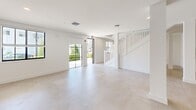 This contemporary residence offers 1950 square feet of living space spread across two floors. The ground floor spans 1020 square feet, while the upper level measures 920 square feet. The home boasts three bedrooms, including a primary suite of 130 square feet, and three full bathrooms.

The interior is characterized by a clean, minimalist aesthetic with crisp white walls and light-toned flooring throughout. Large windows in the living areas and bedrooms flood the space with natural light, creating an airy ambiance. The kitchen features sleek white cabinetry, stainless steel appliances, and track lighting, embodying modern functionality.

Bathrooms are appointed with glass-enclosed showers, modern fixtures, and neutral-toned tile work. The home includes two closets for ample storage, complemented by wire shelving systems for organization.

A standout feature is the spacious balcony, offering views of the surrounding area and providing an ideal outdoor living space. The balcony is adorned with tropical vegetation, enhancing its resort-like feel.

The open floor plan promotes a sense of spaciousness and fluidity between living areas. High ceilings and recessed lighting fixtures contribute to the overall contemporary ambiance. This residence combines style and comfort in a well-designed, modern package.