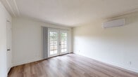 Located at 4249 Nobel Dr in San Diego's University City neighborhood, this one-bedroom, one-bathroom residence offers a thoughtfully arranged single-floor layout. The open-plan living room and kitchen area serves as the heart of the home, featuring light wood-style flooring, crown molding, and a wall-mounted mini-split HVAC unit for year-round comfort. French doors flood the living space with natural light and provide direct access to the outdoors, offering pleasant views of the surrounding greenery. The kitchen is well-appointed with rich warm-toned wood cabinetry, granite countertops, a stainless steel refrigerator, built-in microwave, electric range, and a dishwasher — all set atop the same light wood-style flooring that carries through the main living area. The bedroom is a comfortable, carpeted retreat with a bright window framing outdoor foliage, creating a calm and private atmosphere. A dedicated closet provides convenient storage. The full bathroom continues the cohesive design language with wood cabinetry, granite countertops, wood-style flooring, and a tiled shower-tub combination. Clean white walls and neutral finishes throughout give this residence a bright, move-in-ready feel.